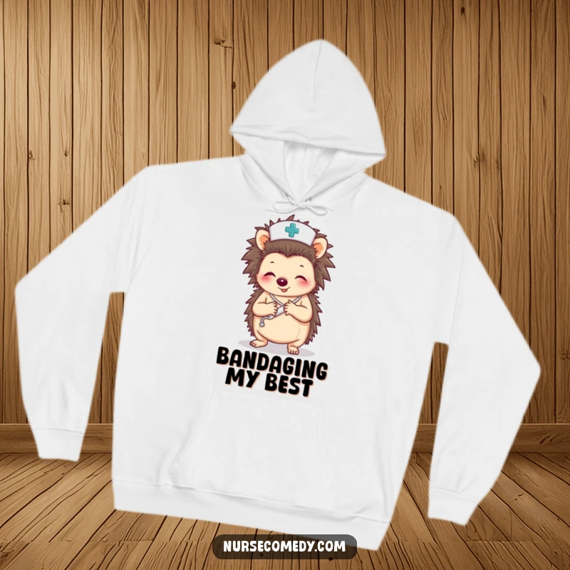 Funny hoodie featuring a hedgehog nurse character meticulously wrapping a paw with a bandage, symbolizing dedication.